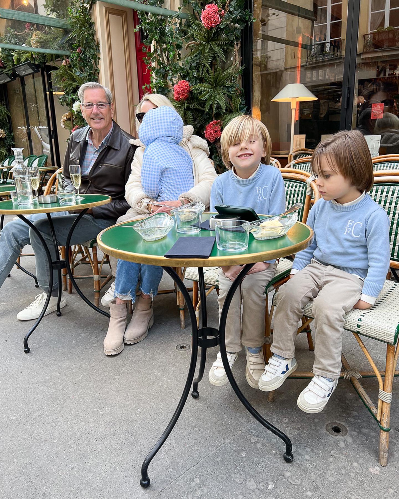 family sitting outside a paris cafe