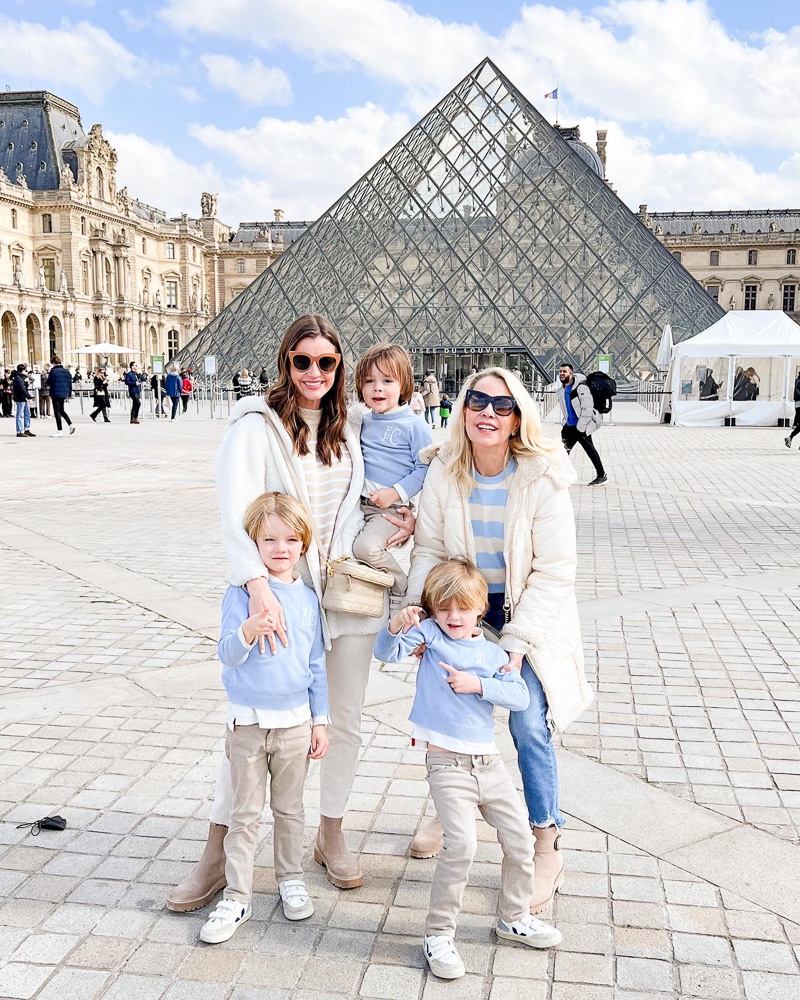 two women with three little boys outside the louvre pyramid