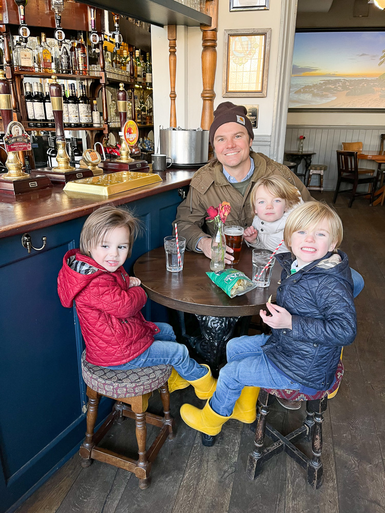 dad sitting with three little boys in pub london