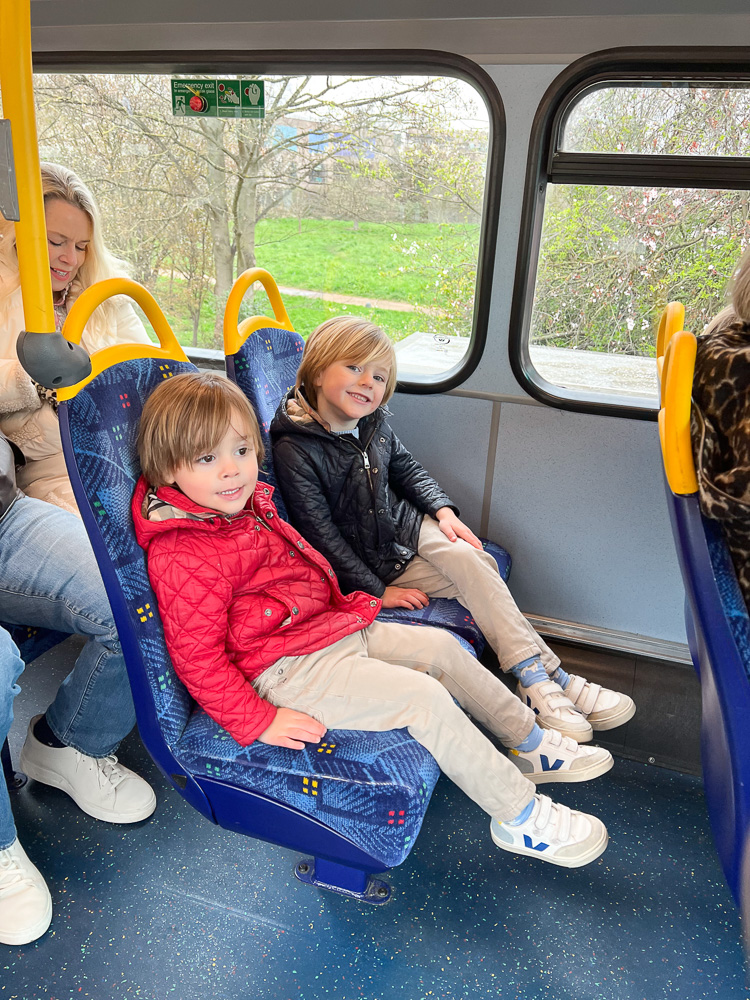 two little boys riding on double decker bus in london