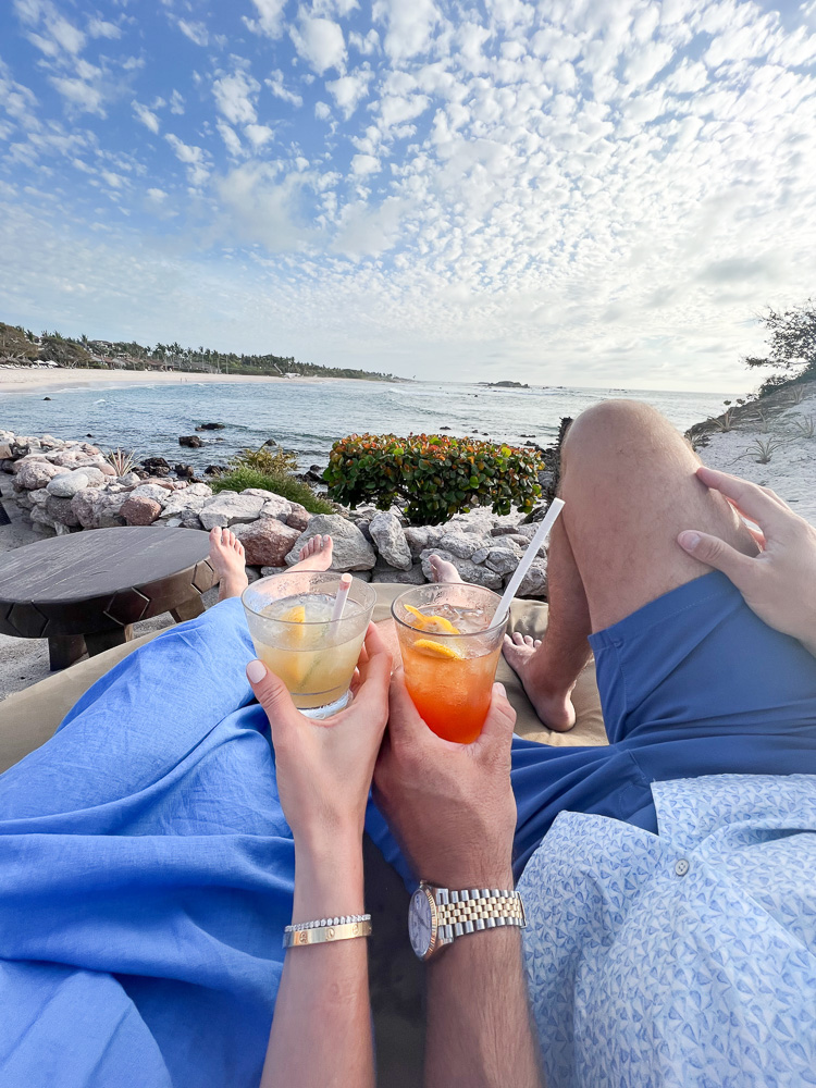 couple sitting with cocktails at the beach