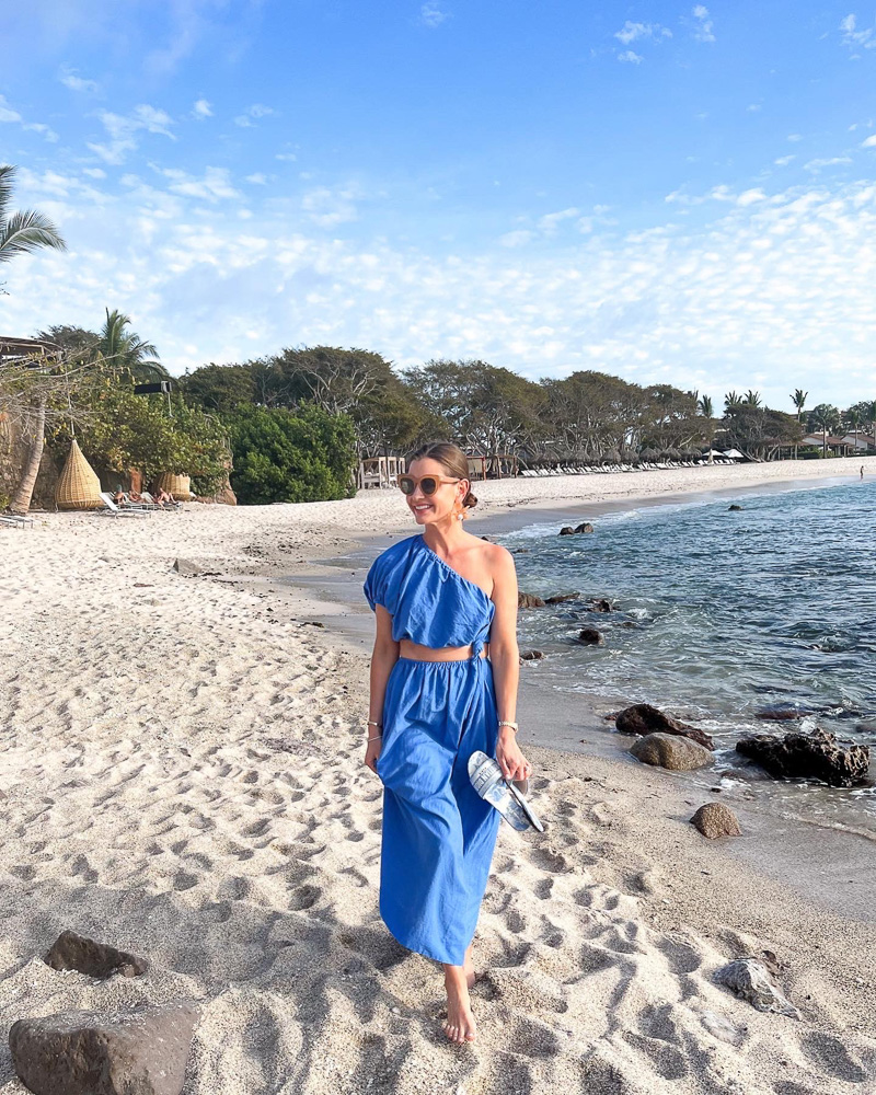 woman walking on the beach in blue dress