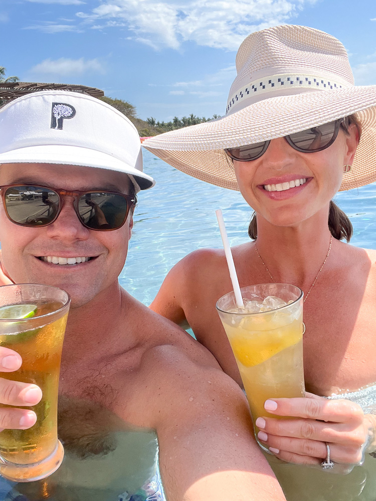 couple in pool with cocktails