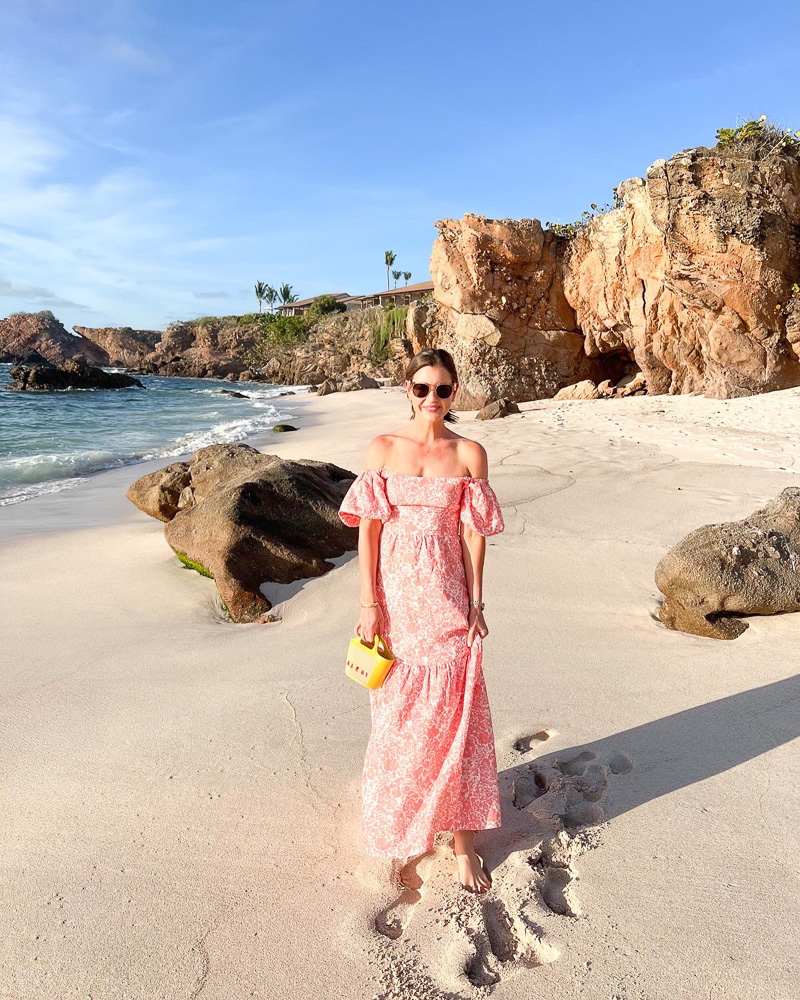woman in coral maxi dress at the beach