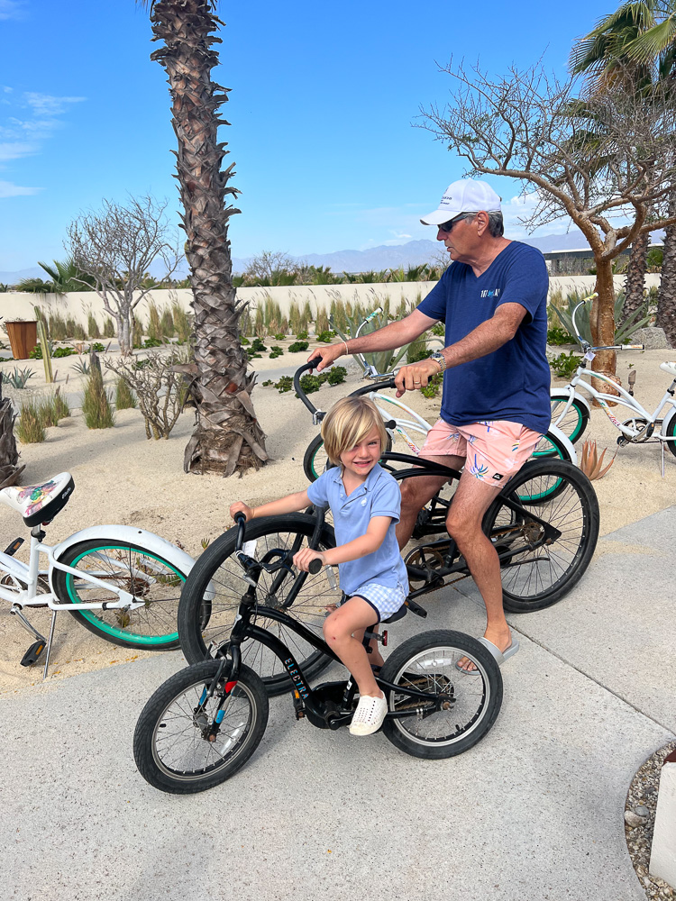 man and little boy on bikes at the beach