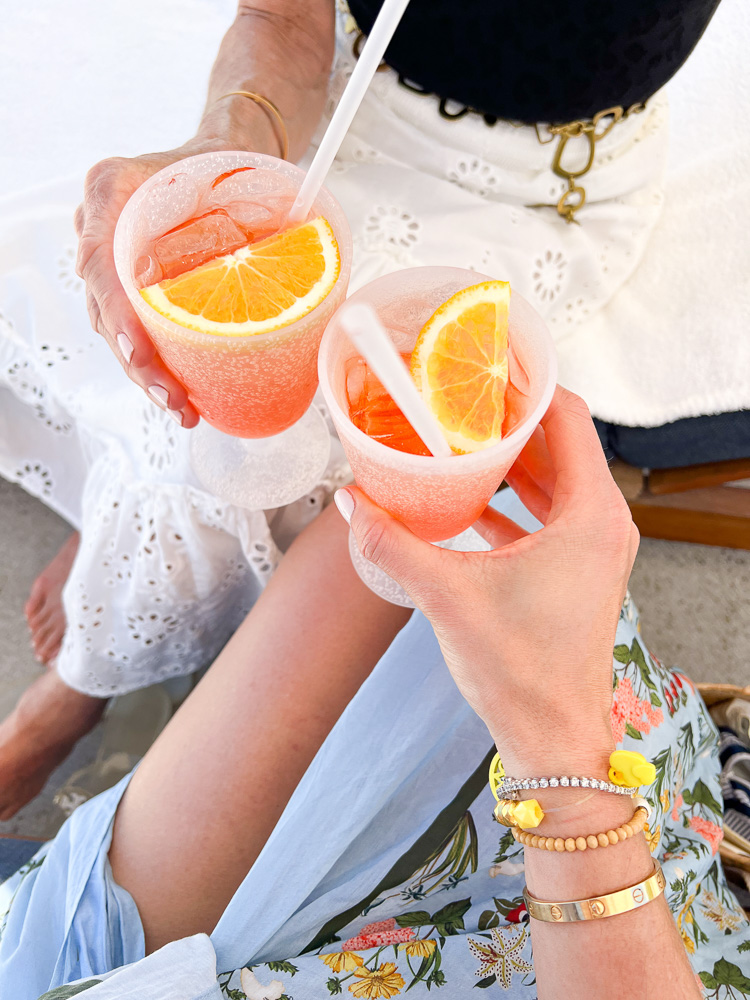 two women toasting with orange cocktails