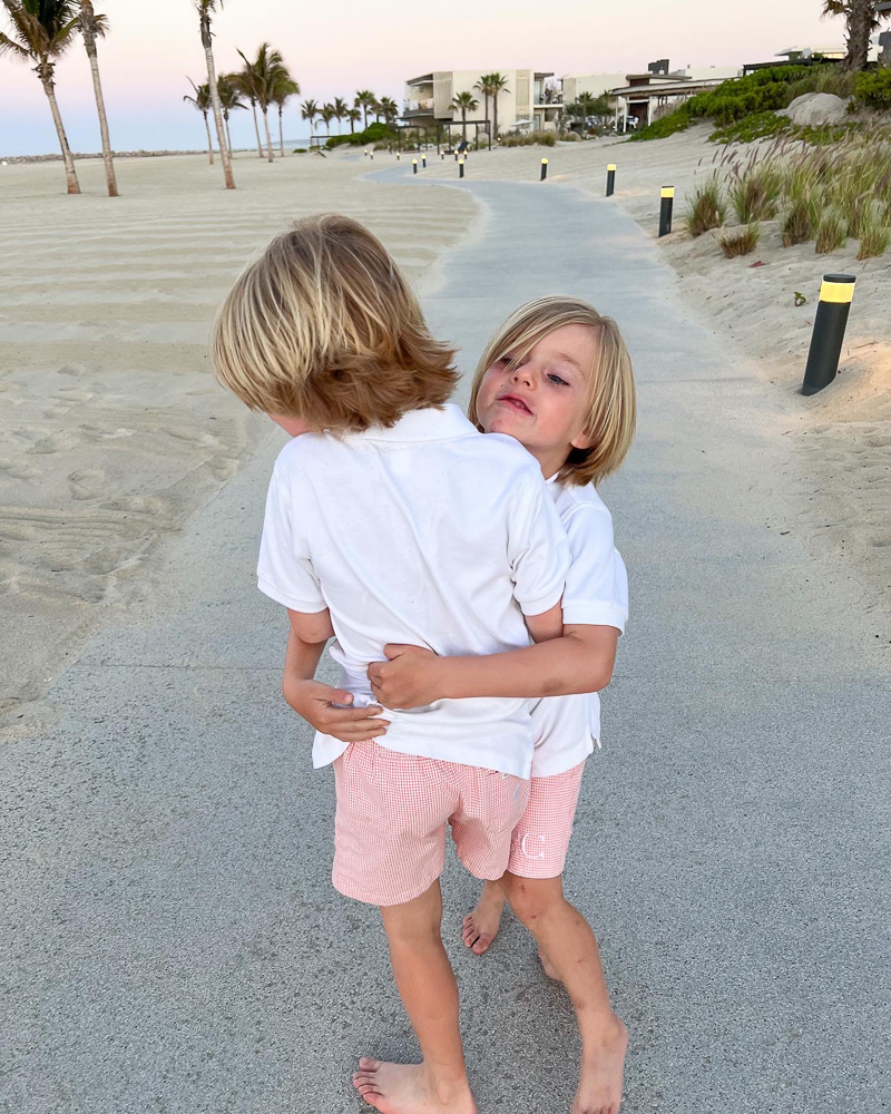 two young brothers hugging at the beach
