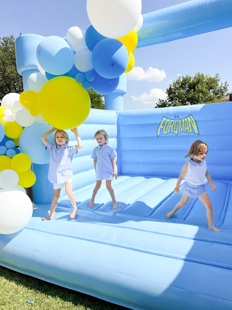 three little boys jumping in blue bounce house