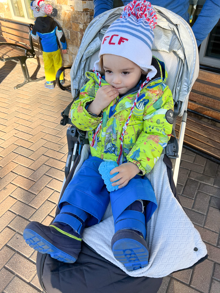 toddler boy dress for winter sitting in stroller