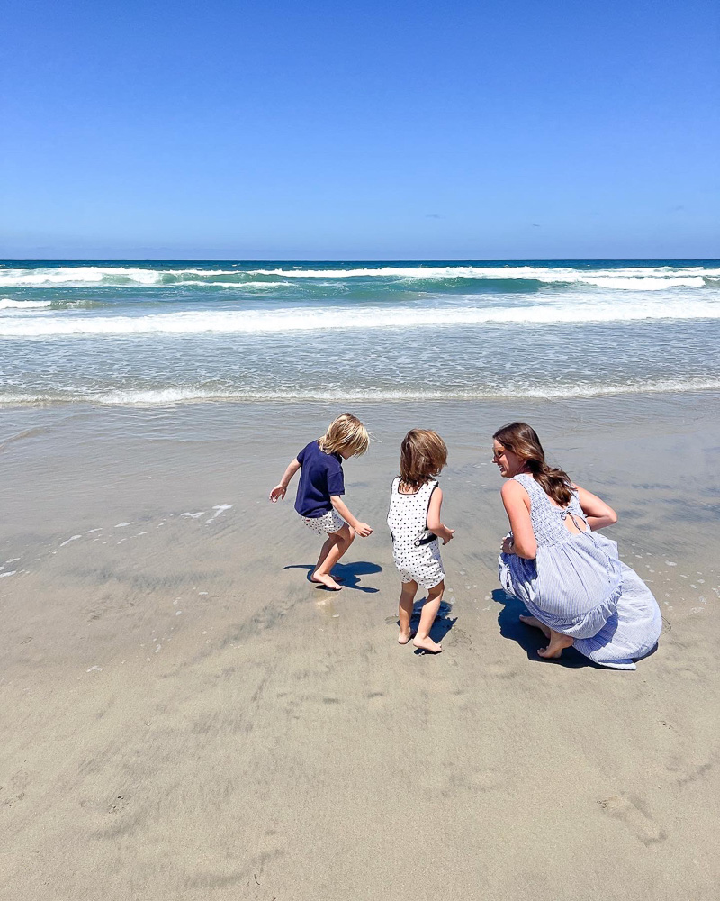 woman with two little boys at the beach