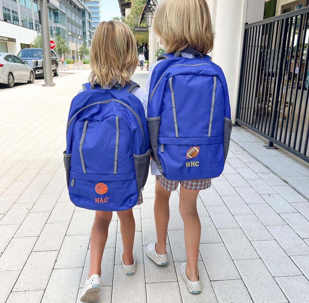 two brothers walking away wearing blue personalized backpacks