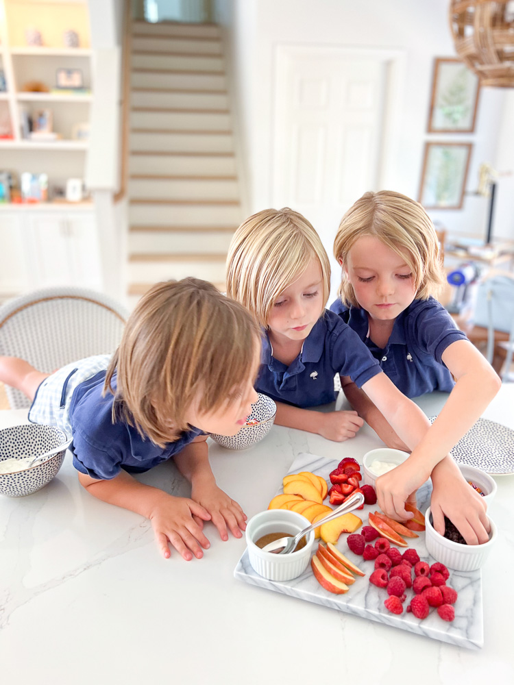 three little boys reaching for after school snack board