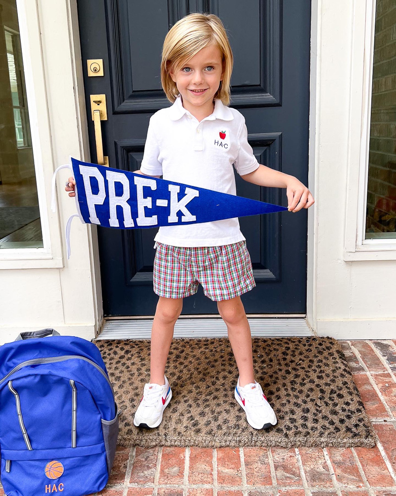 little boy standing on front porch with pre-K sign