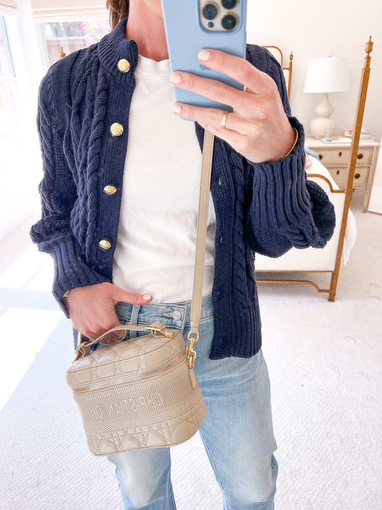 woman wearing blue cable cardigan with gold buttons and jeans