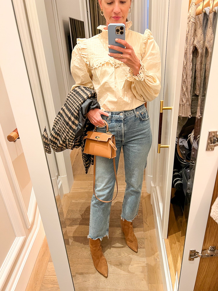 mirror selfie of woman in ruffle collar blouse and jeans