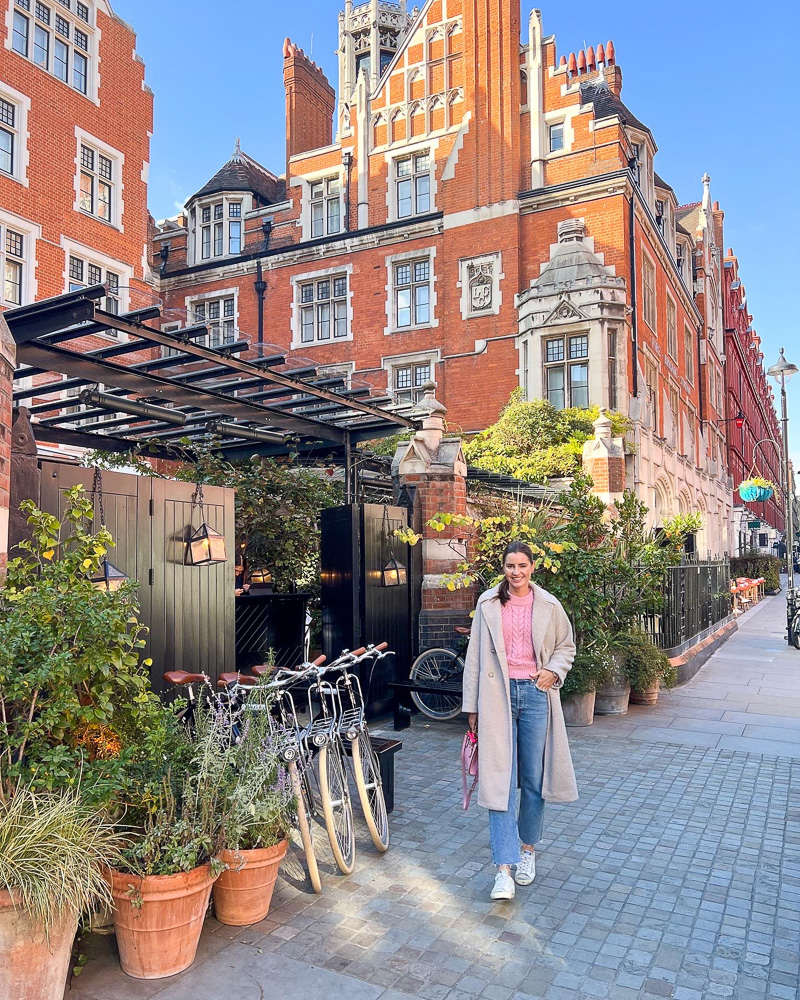woman wearing a long coat standing on london street