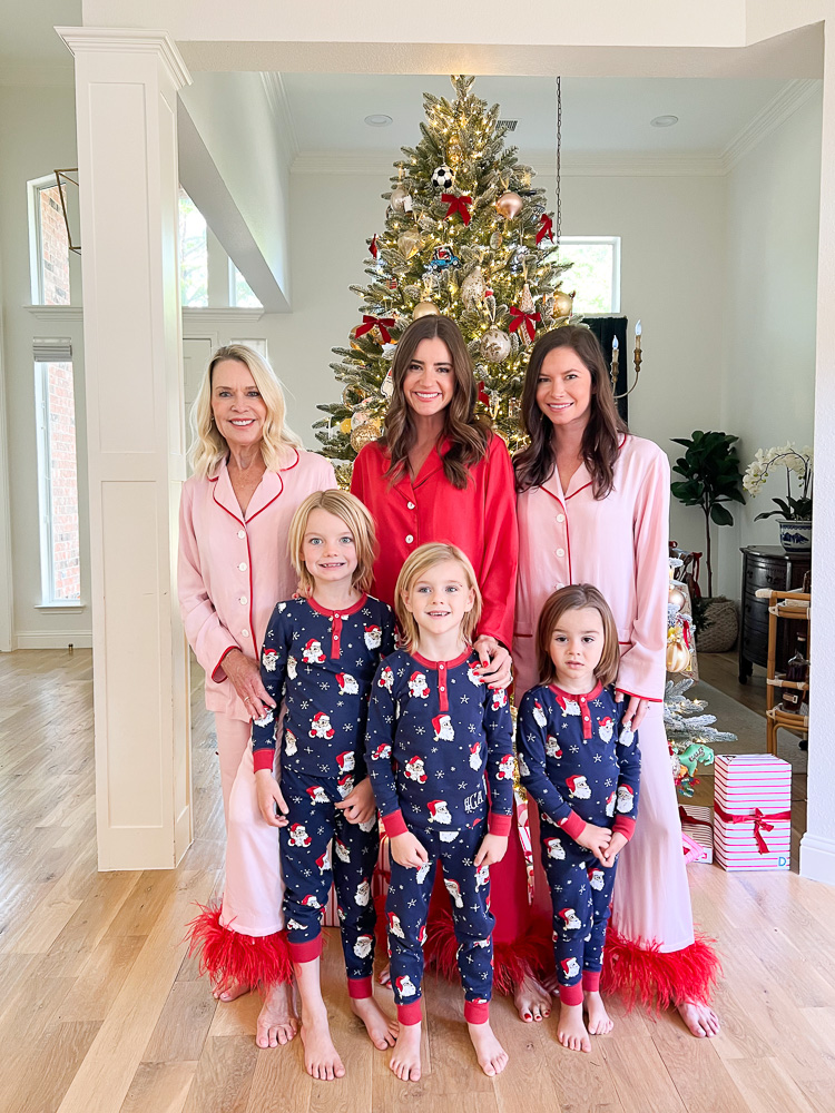 three women with three little boys standing in front of christmas tree in matching pajamas