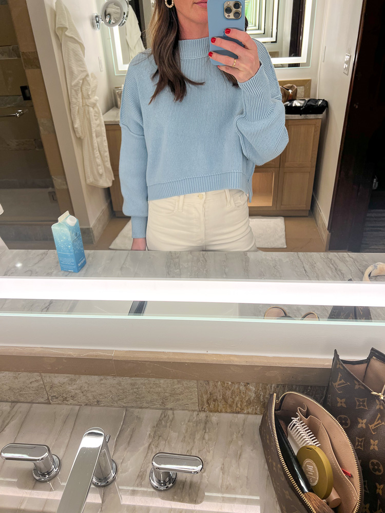 woman in front of mirror waring blue sweater