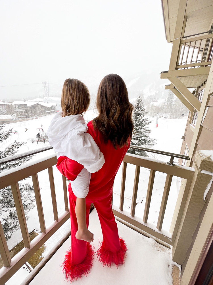 mom in feather pajamas holding toddler in bathrobe view of snow FS jackson hole