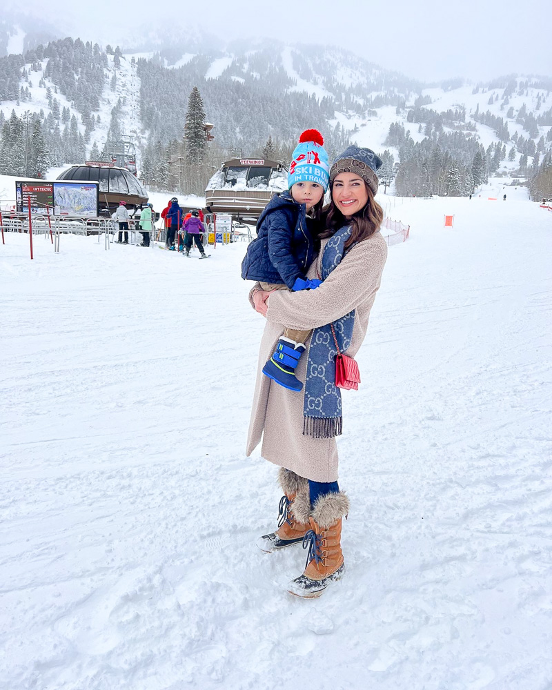 mom holding boy standing in the snow ski slopes teton village WY