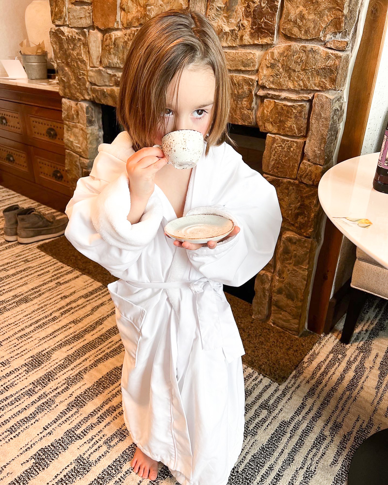 toddler boy in bathrobe drinking from coffee cup