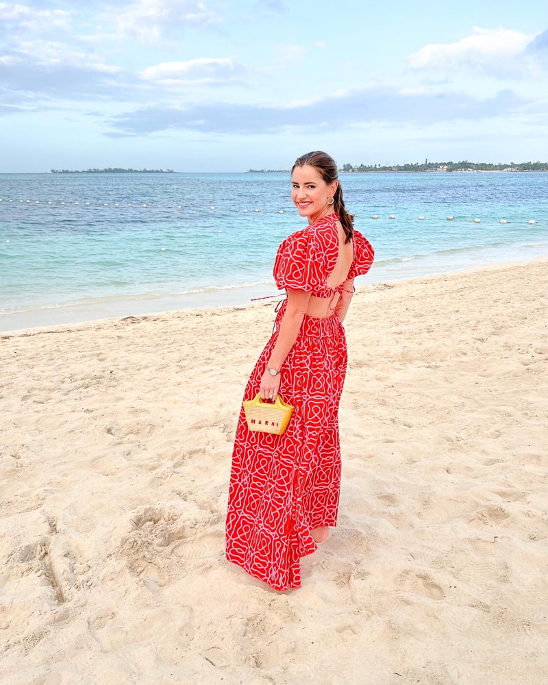 woman standing on the beach in red maxi dress