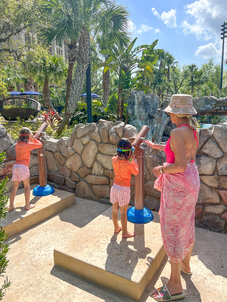 woman and two young noys playing with water guns four seasons orlando