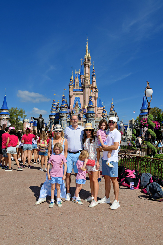 family standing in front of the castle at walt disney world