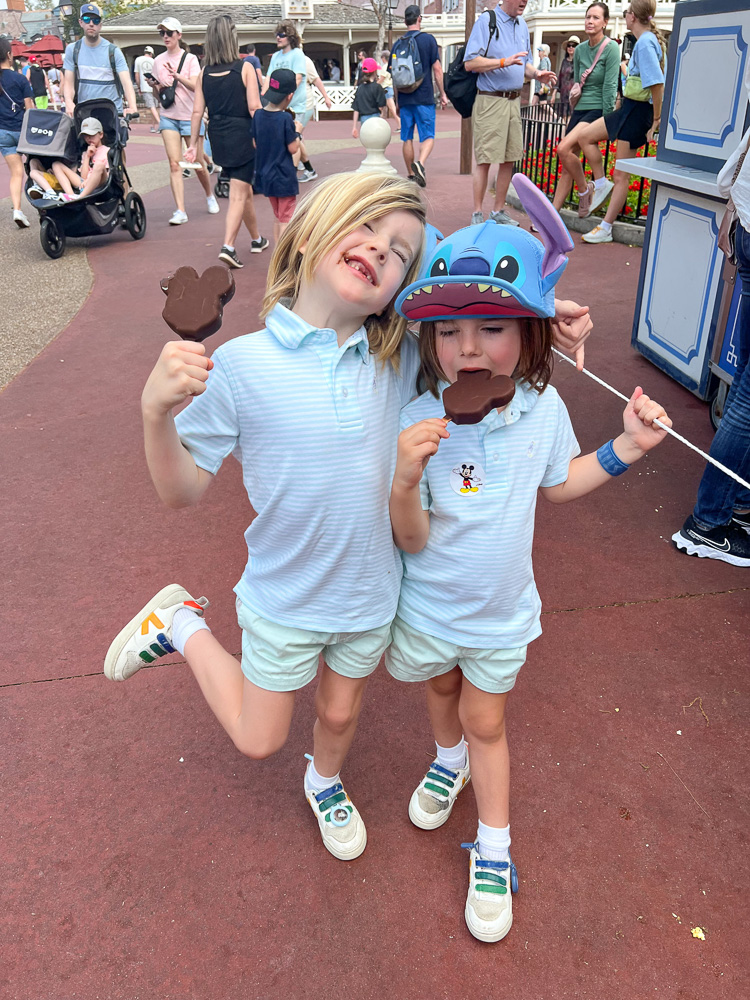 two little boys eating mickey ice cream bars at disney world