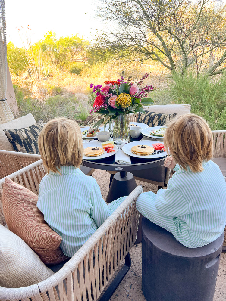 two little boys having breakfast on patio