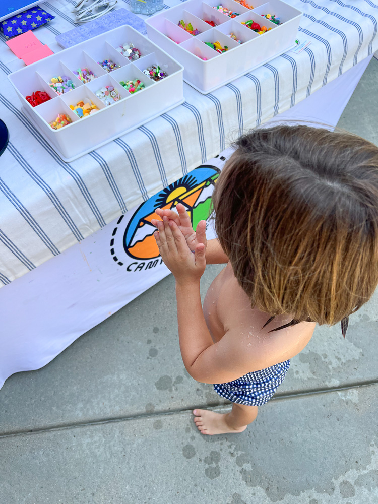 little boy standing in front of sunglass craft table