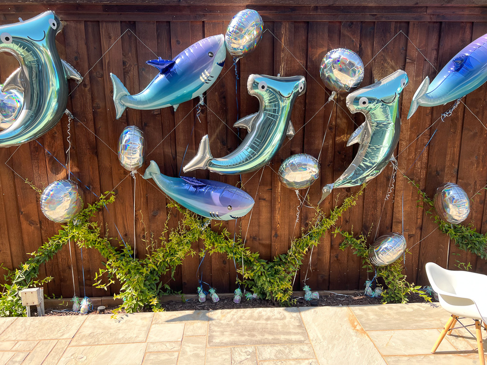 shark balloons attached to a fence
