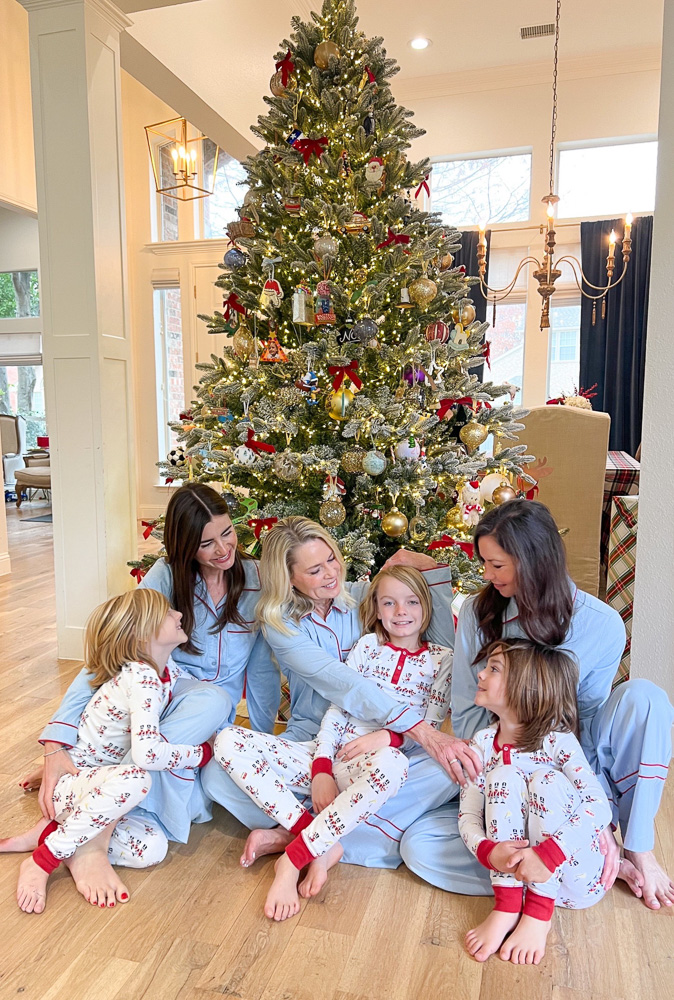 family gathered under the tree in matching christmas pajamas