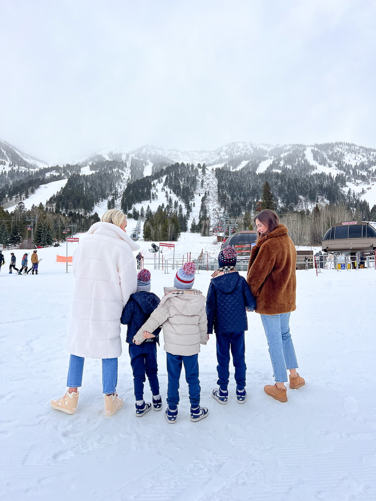 group standing in the snow on a family ski trip four seasons jackson hole