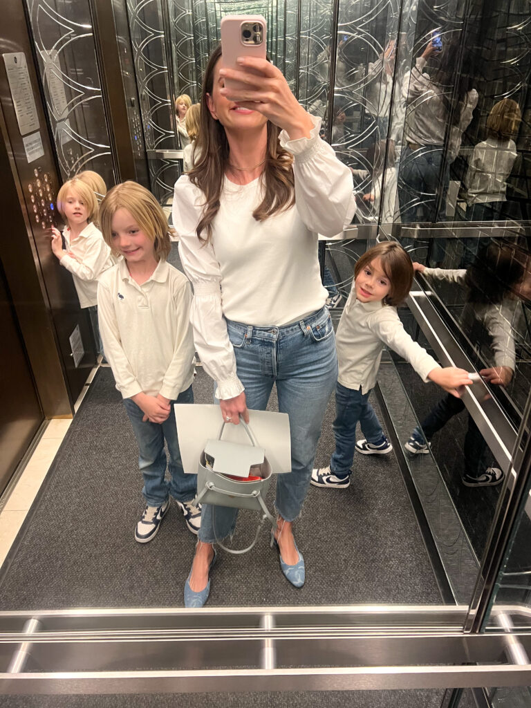 mom taking a selfie in an elevator with three little boys