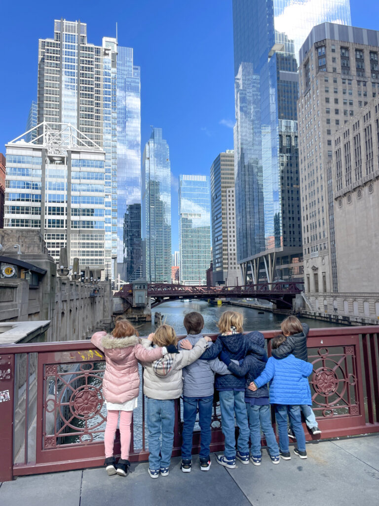 a group of small children huggin overlooking the chicago river