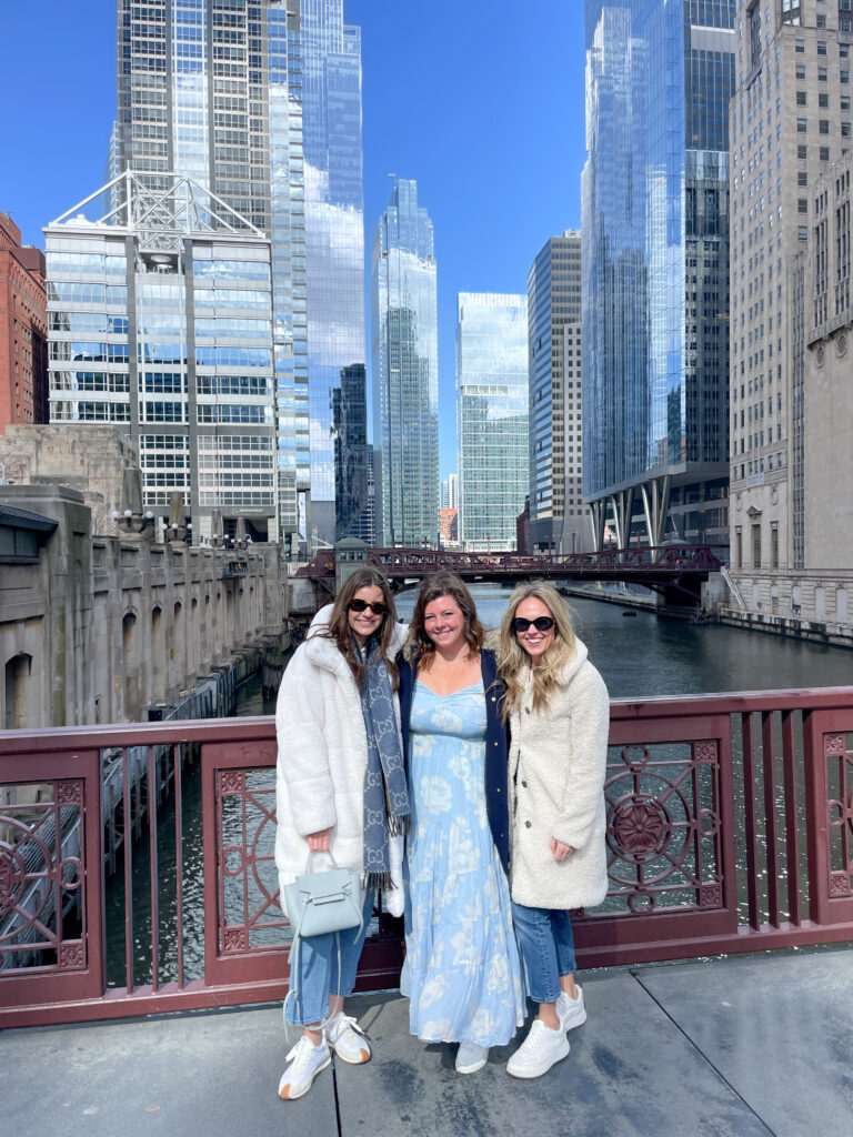 three women standing on chicago bridge over the river